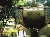 Стас на фоне памятника какому-то танку в парке